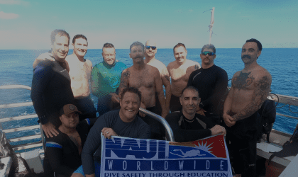 A group of people standing on top of a boat.