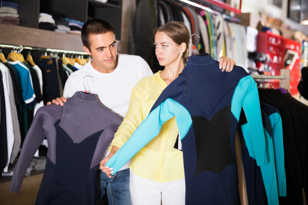 A man and woman looking at clothes in a store.