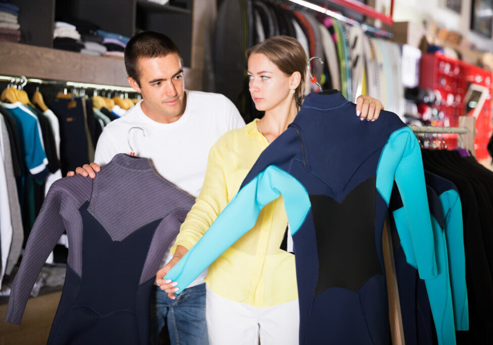 A man and woman looking at clothes in a store.